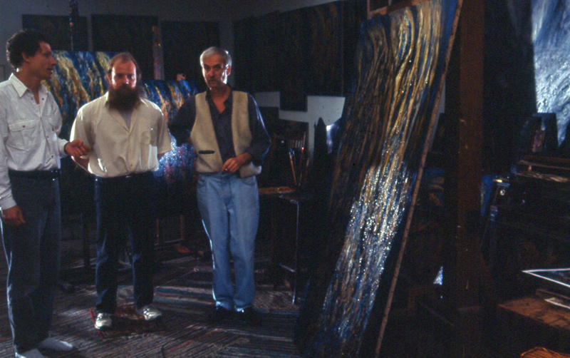 Group gathered beside a tall abstract artwork