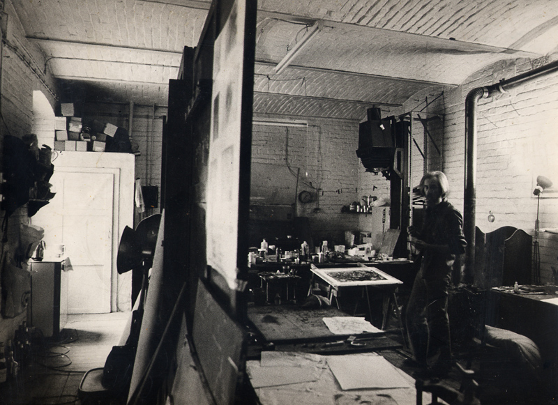 Black-and-white view of a studio filled with canvases